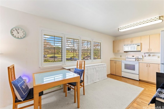 kitchen featuring light brown cabinetry, white appliances, and light wood-type flooring