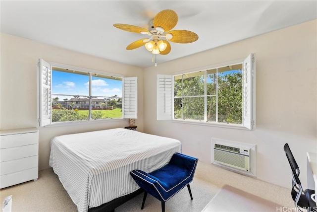 bedroom featuring multiple windows, ceiling fan, light colored carpet, and a wall unit AC