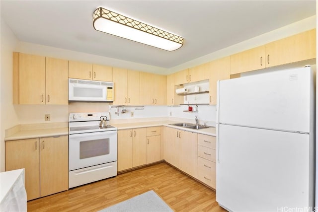 kitchen with light brown cabinetry, sink, white appliances, and light hardwood / wood-style floors