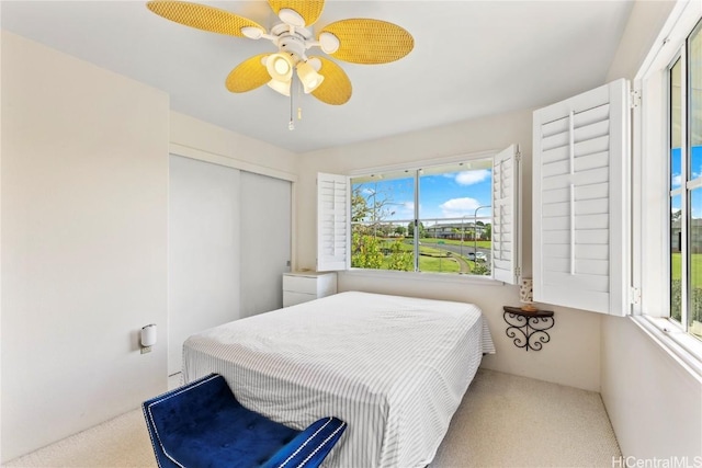 bedroom with carpet, ceiling fan, and a closet