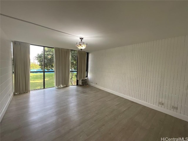 unfurnished room with hardwood / wood-style floors and an inviting chandelier