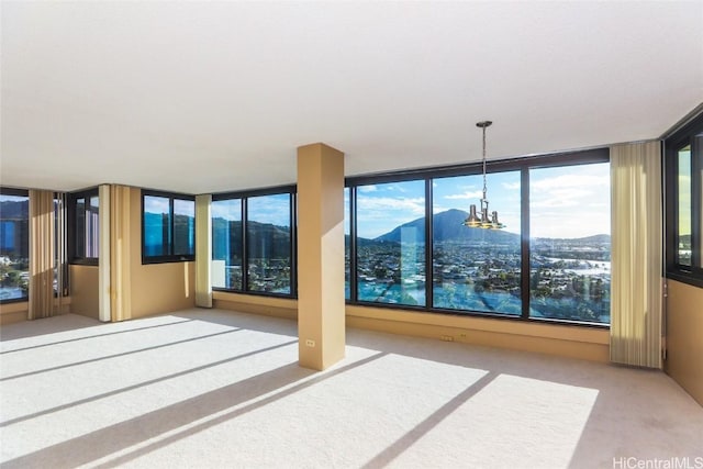 interior space featuring a notable chandelier, a mountain view, and carpet flooring