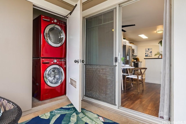 laundry area featuring laundry area, stacked washer / drying machine, and wood finished floors