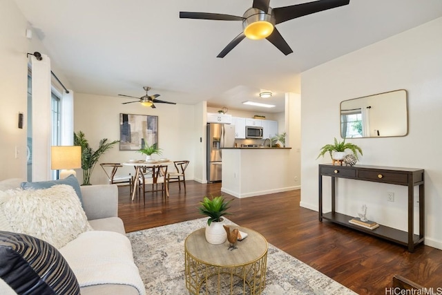 living room with dark wood-style floors, a healthy amount of sunlight, and baseboards