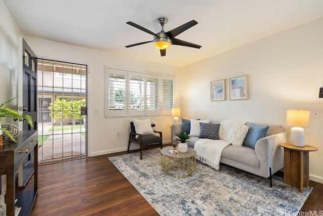 living area featuring dark wood-style floors, ceiling fan, and baseboards