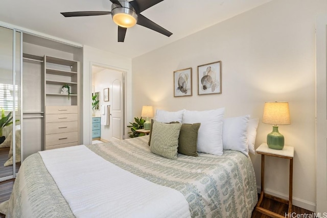 bedroom featuring a ceiling fan, a closet, dark wood finished floors, and baseboards