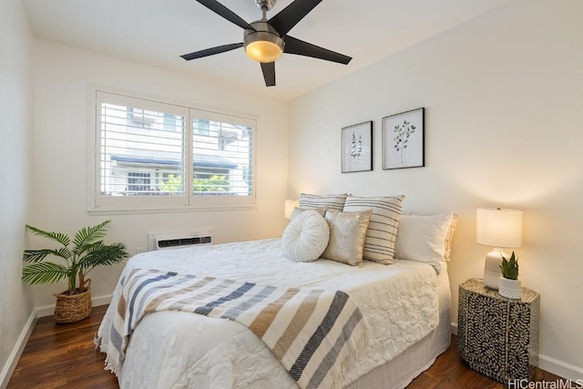 bedroom featuring dark wood-style floors, a wall mounted AC, a ceiling fan, and baseboards