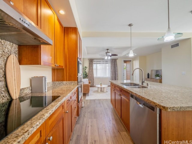 kitchen featuring sink, decorative light fixtures, a center island with sink, appliances with stainless steel finishes, and exhaust hood