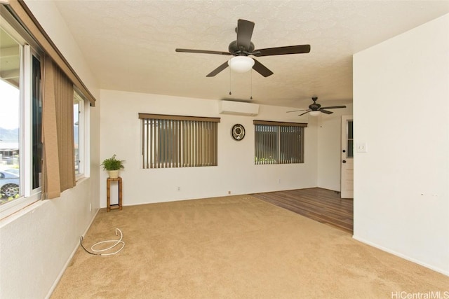 carpeted empty room featuring a wall mounted AC and a textured ceiling