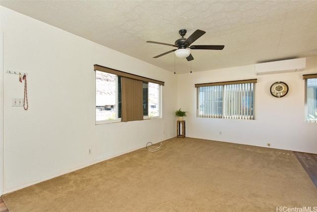 carpeted spare room featuring ceiling fan, a wall mounted AC, and a textured ceiling