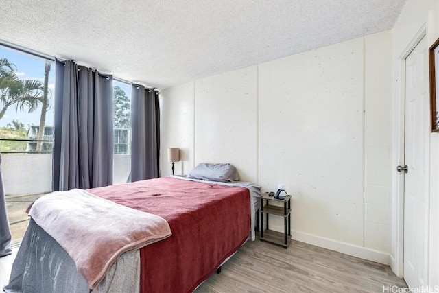 bedroom with light hardwood / wood-style floors and a textured ceiling