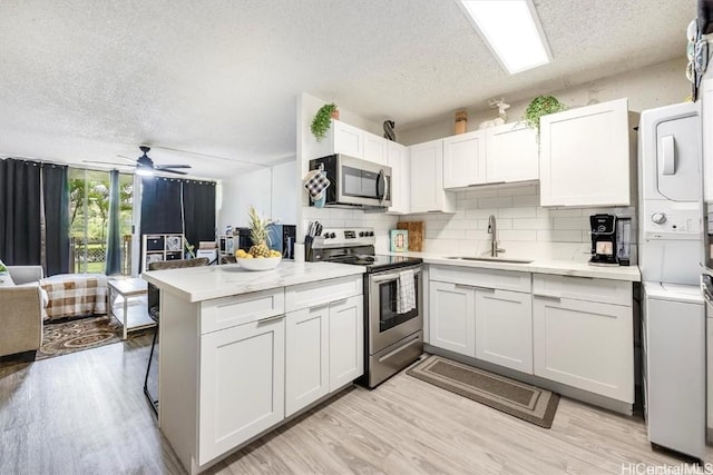 kitchen with white cabinetry, appliances with stainless steel finishes, sink, and light hardwood / wood-style flooring