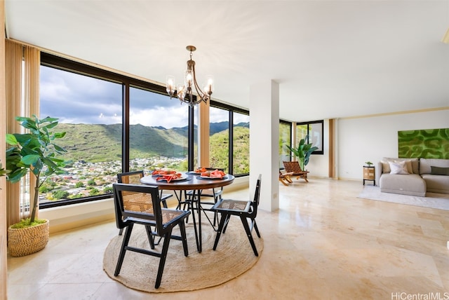 dining room with a chandelier, a healthy amount of sunlight, and a mountain view