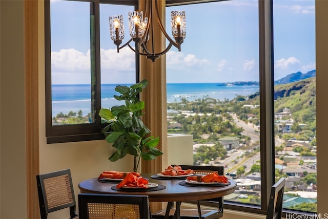 dining space featuring a water view and an inviting chandelier