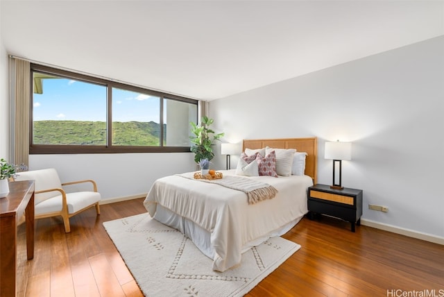 bedroom with dark hardwood / wood-style flooring