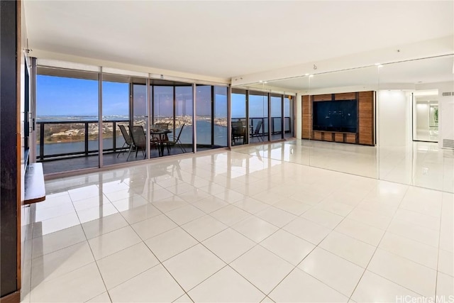 spare room featuring tile patterned flooring and expansive windows