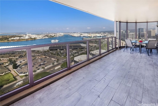 balcony featuring a water view and a city view