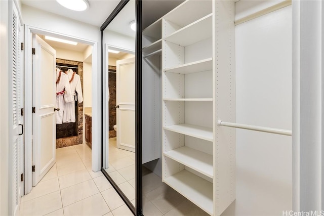 walk in closet with light tile patterned floors