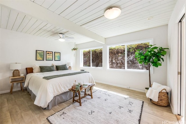 bedroom featuring ceiling fan, light wood-type flooring, wood ceiling, and beam ceiling