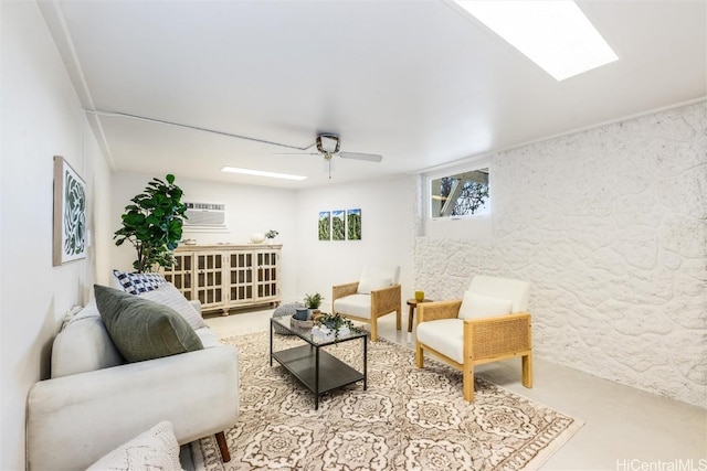 living room with ceiling fan, a wall mounted AC, and a skylight