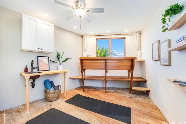 interior space with ceiling fan, sink, and light hardwood / wood-style flooring