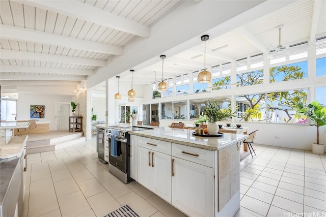 kitchen with pendant lighting, light tile patterned floors, light stone countertops, white cabinets, and stainless steel range with electric cooktop