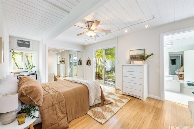 bedroom with multiple windows, a wall mounted AC, access to outside, and light hardwood / wood-style floors