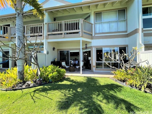 back of property with a yard and a patio area