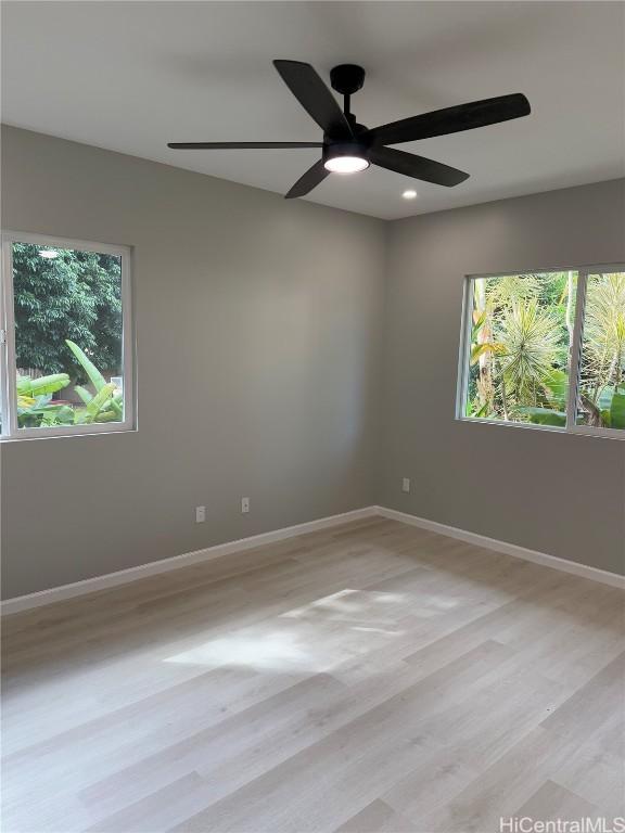 unfurnished room with light wood finished floors, baseboards, and recessed lighting