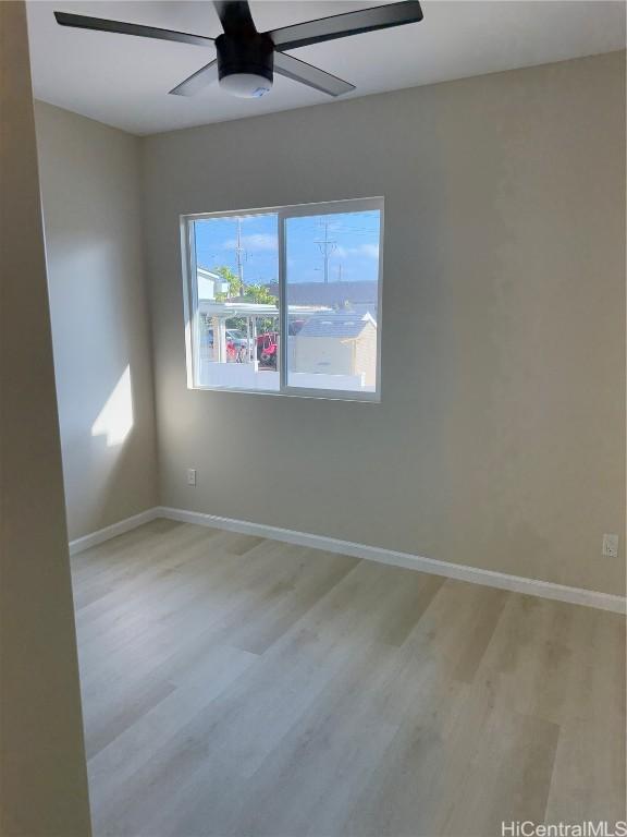 unfurnished room with light wood-type flooring, baseboards, and a ceiling fan