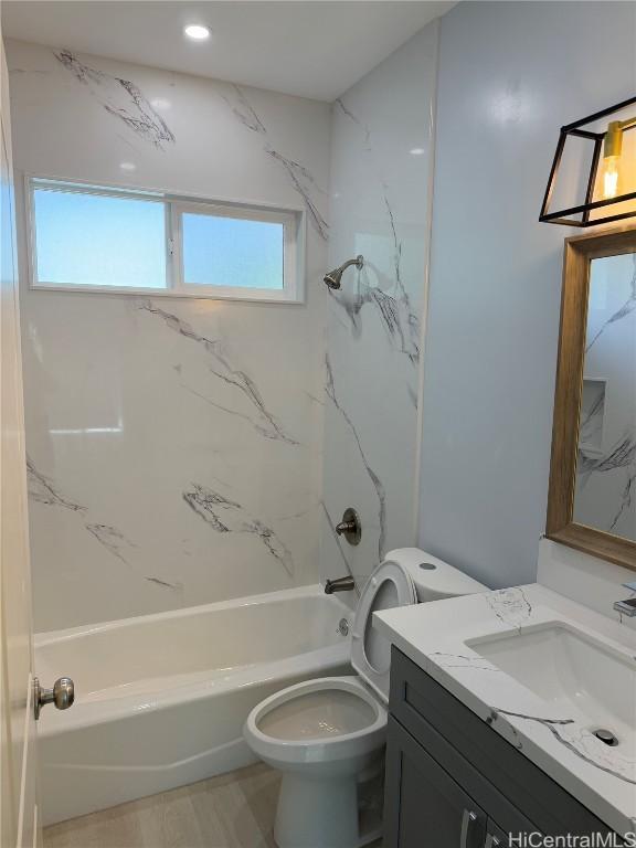 bathroom with washtub / shower combination, vanity, and toilet