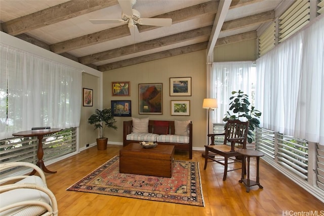 interior space featuring a ceiling fan, lofted ceiling with beams, baseboards, and wood finished floors