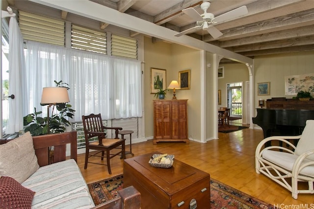 living area with a ceiling fan, beamed ceiling, baseboards, and wood finished floors