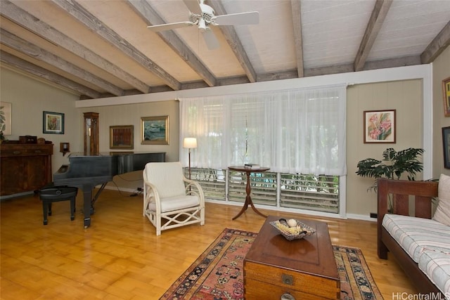 living area featuring lofted ceiling with beams, ceiling fan, a wealth of natural light, and wood finished floors