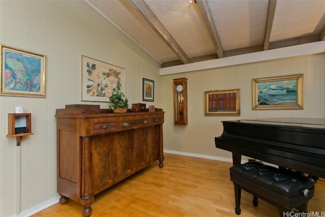 sitting room featuring baseboards, beam ceiling, and light wood-style floors