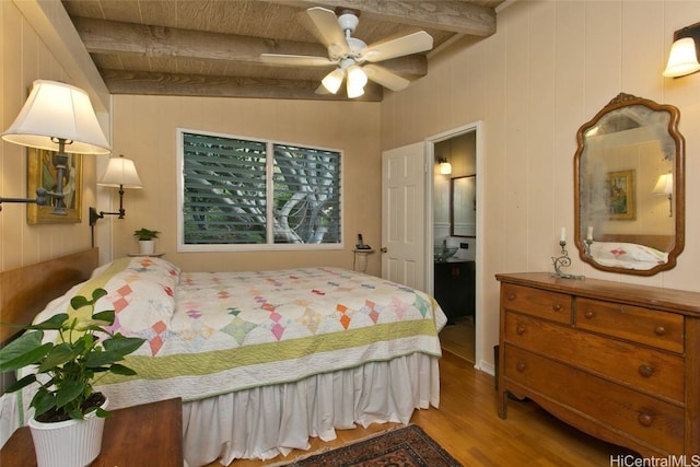 bedroom with beamed ceiling and wood finished floors