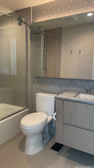 full bathroom with toilet, shower / bath combination with glass door, vanity, tile patterned flooring, and backsplash