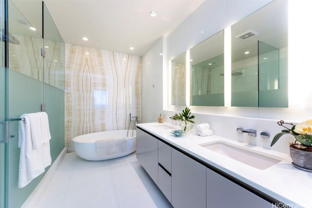 bathroom featuring double vanity, a soaking tub, visible vents, a stall shower, and a sink