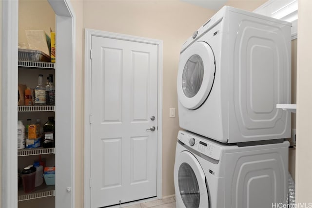 washroom with stacked washer and dryer and laundry area