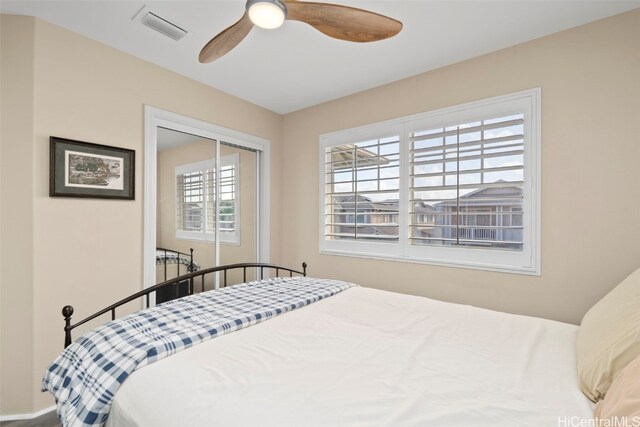 bedroom with a closet, visible vents, baseboards, and a ceiling fan