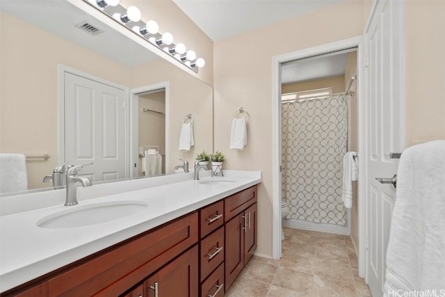 bathroom with double vanity, visible vents, curtained shower, and a sink