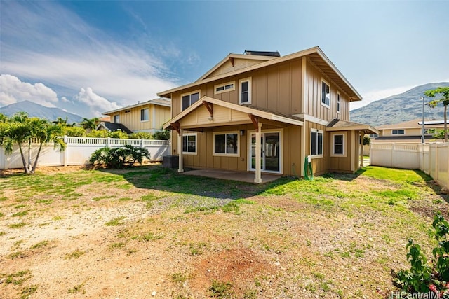 rear view of house featuring a patio, a yard, and a mountain view