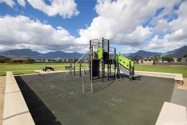 view of play area with a mountain view and a lawn