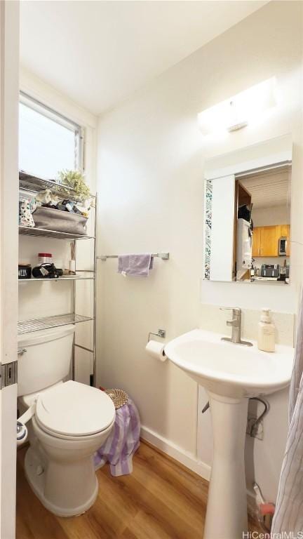 bathroom featuring hardwood / wood-style flooring and toilet