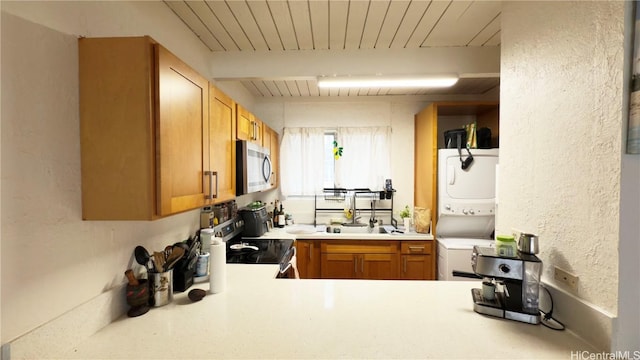 kitchen with stacked washer and clothes dryer, sink, wood ceiling, stainless steel appliances, and beam ceiling