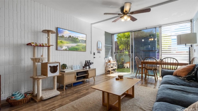 living room with expansive windows, ceiling fan, and hardwood / wood-style floors