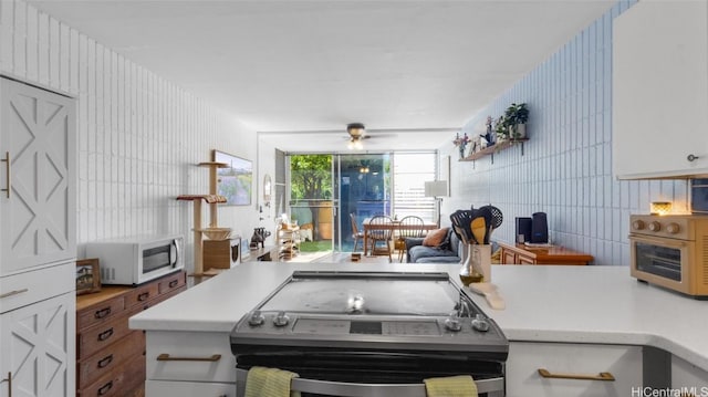 kitchen with white cabinetry, stainless steel electric range oven, and ceiling fan