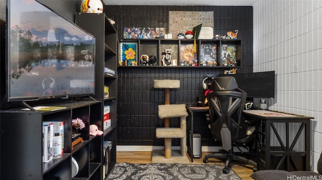 home office featuring hardwood / wood-style floors and tile walls