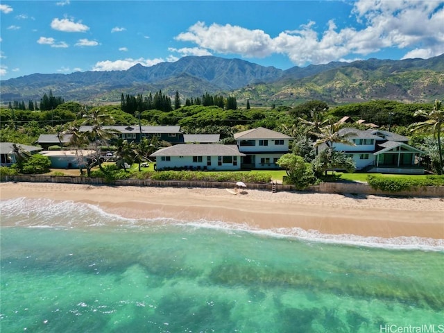 drone / aerial view featuring a water and mountain view and a beach view