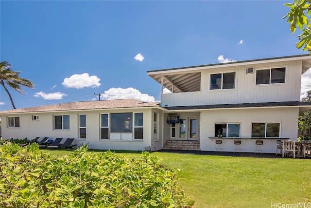 rear view of house featuring a lawn